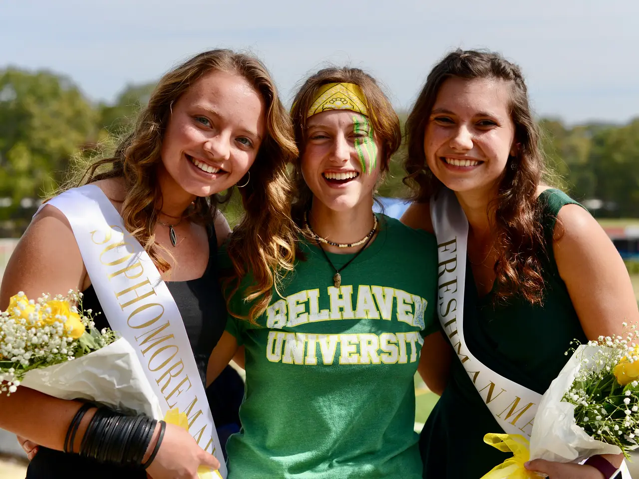 Three happy students at homecoming.