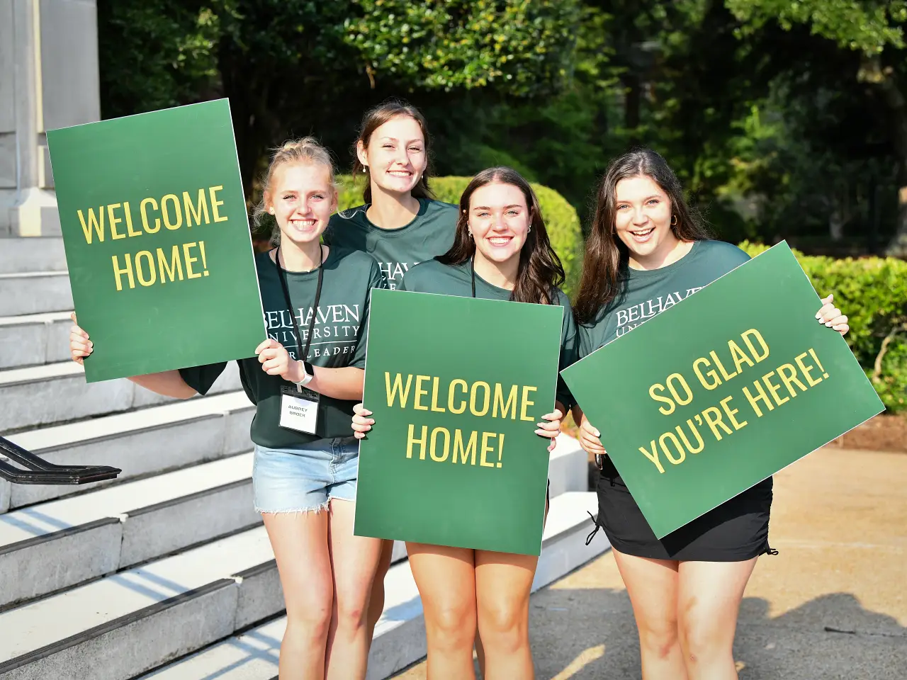 4 students holding welcome signs